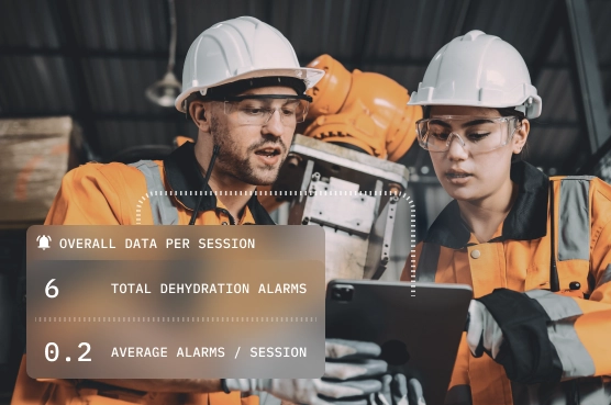 Connected hydration 5 Workers reviewing dehydration alarm data on tablet.